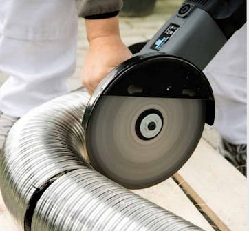 Montere peisinnsats: Det fleksible røret tilpasses i lengden med en vinkelsliper Montere peisinnsats: Det fleksible røret tilpasses i lengden med en vinkelsliper